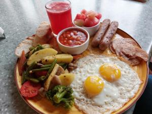 a plate of breakfast food with eggs sausage and vegetables at The Lodgers Luxury Hotel Near Golf Course Road Gurgaon in Gurgaon