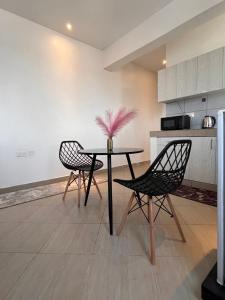 a dining room with a table and two chairs at Haller Park Apartments Pacific Bamburi in Mombasa +3 photos