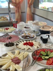 einen Tisch mit Käseplatten und anderen Lebensmitteln in der Unterkunft Hotel Vila Misiri in Durrës