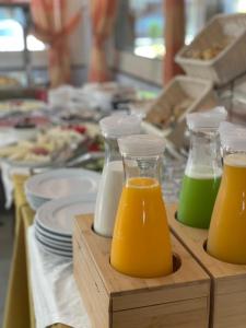 duas garrafas de sumo de laranja numa mesa com pratos em Hotel Vila Misiri em Durrës