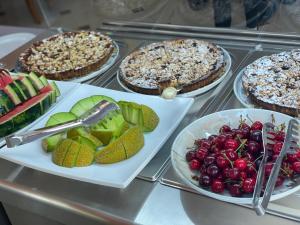 um buffet de tartes e frutas em pratos numa mesa em Hotel Vila Misiri em Durrës