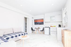 - un salon blanc avec un canapé et une table dans l'établissement Sol Apartments Corfu by Estia, à Corfou