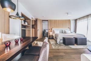 a bedroom with a bed and a desk and chairs at Elizabeth Arthotel in Ischgl