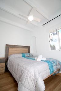 a white bedroom with a bed and a ceiling fan at Duplex Mojácar Beach in Mojácar