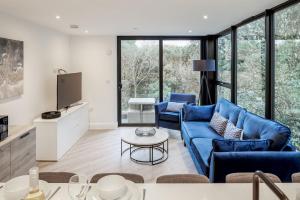 een woonkamer met een blauwe bank en een tafel bij Aurora South in Poole