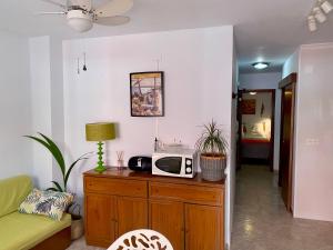 una sala de estar con microondas en un armario de madera en A 1 min de las playas norte y sur, en Peñíscola