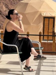 Kylie magic camp في وادي رم: امرأة تجلس على كرسي ورجليها متقاطعتان