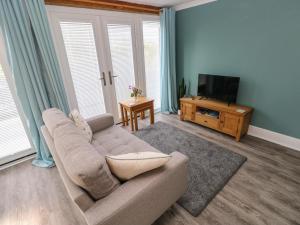 ein Wohnzimmer mit Couch und Flachbildfernseher in der Unterkunft Tower Cottage in Pembroke