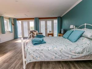 ein Schlafzimmer mit einem weißen Bett und blauen Wänden in der Unterkunft Tower Cottage in Pembroke