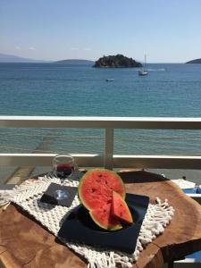 トロにあるArcadia Luxury Rooms Seaside Cuisineのテーブルの上に置かれたスイカのスライスとワイングラス