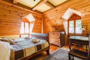 a bedroom with a bed in a wooden cabin at Dwór Zaścianek in Sarnaki