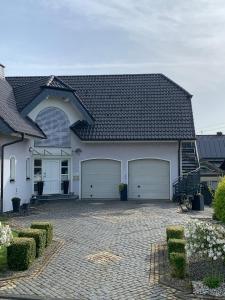 a large white house with two garage doors at Ferienwohnung Leonardo in Badem