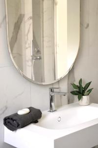 een badkamer met een wastafel en een spiegel bij el'Gio Feel at Home in Pordenone