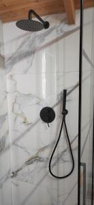 a bathroom with a black shower head on the wall at Lodges Shen Nikolla in Dhërmi