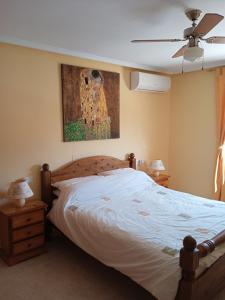 een slaapkamer met een bed en een schilderij aan de muur bij Pete's Place in La Marina