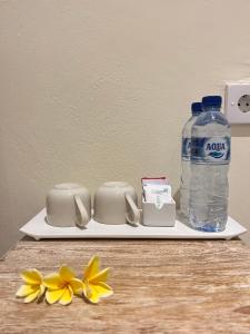 a plate with a bottle of water and yellow flowers at Pondok Raamshanti Lembongan in Nusa Lembongan