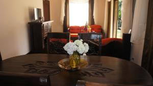 una mesa de comedor con un jarrón de flores. en Casa Andalucia Apartments, en Santo Domingo