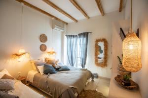 トロにあるArcadia Luxury Rooms Seaside Cuisineの窓のある部屋にベッドがある寝室