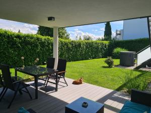 un patio con una mesa y sillas y un gato sentado en él en peter@home 