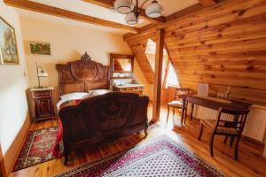 a bedroom with a large wooden bed and a desk at Dwór Zaścianek in Sarnaki