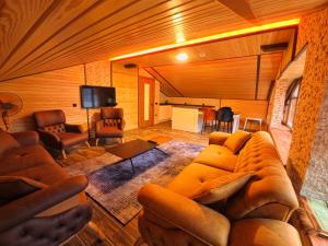 a living room with a couch and a tv at Danis Otel Ve Restoran in Uzungol