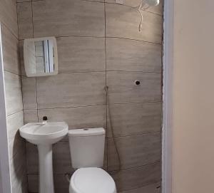 a small bathroom with a toilet and a sink at MACEDO HOSPEDAGEM in Mateiros