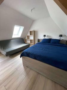 een slaapkamer met een blauw bed en een raam bij Village house 3 bedrooms large terrace - Dodo et Tartine in Villedieu-les-Poëles