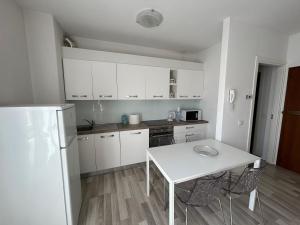 a kitchen with a white table and a white refrigerator at Casa Vanny in Colico