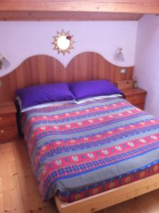 a bedroom with a bed with a wooden head board at Appartamento Ivo in Campitello di Fassa