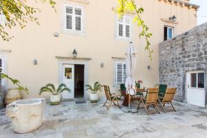 une terrasse avec des chaises et un parasol en face d'un bâtiment dans l'établissement Orka Apartments, à Dubrovnik