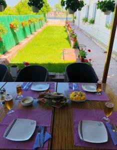 ミラ・ドワゼチ・シ・トレイにあるHANUL PESCARILOR Mila 23の紫ナプキンと食べ物を載せた木製テーブル