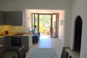 a kitchen and a living room with a table at Cala Sinzias beach house with stunning views in Costa Rei +20 photos