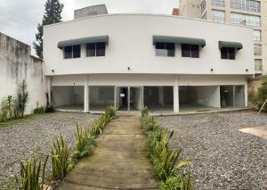 un edificio blanco con un camino delante de él en GMP suites en San Miguel de Tucumán
