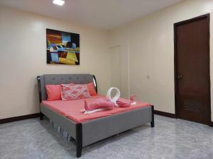 - une chambre avec un lit doté de draps roses et d'oreillers roses dans l'établissement T&J Guest House, 