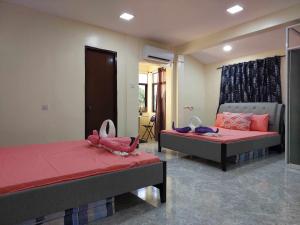 a bedroom with two beds with pink sheets at TJ Residence in San Policarpo