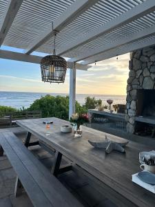 a wooden picnic table with a view of the ocean at The Beach House - Glentana in Glentana