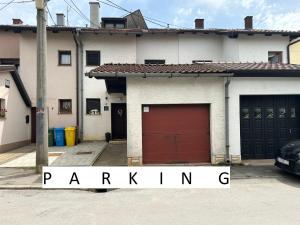 uma casa com uma garagem com uma porta vermelha em Starlight House em Bjelovar