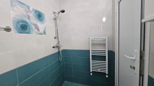 a bathroom with a shower with blue tiles and a ladder at Guest Rooms Kostovi in Nesebar