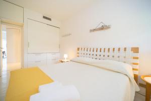 a white bedroom with a large bed and a chalkboard at Residence Scoglietto 50 in Punta Ala