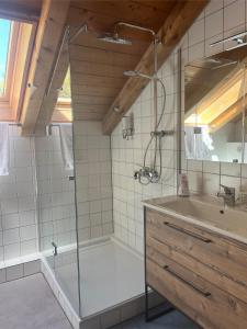 a bathroom with a shower and a tub and a sink at Ferienwohnung Landsberg am Lech in Landsberg am Lech
