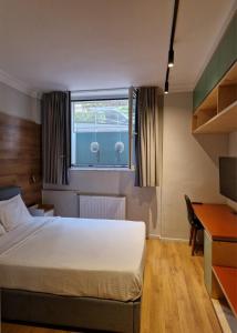 a bedroom with a bed and a desk and a window at Athenian Aura Kolonaki - Feel Athens City Center in Athens