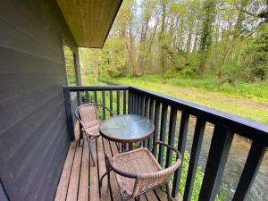 a porch with two chairs and a table on it at Arc Pod-HotTub-HuntersMoon-Warminster-Bath in Warminster