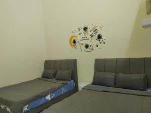 1 dormitorio con 2 camas y reloj en la pared en My Homestay Sitiawan - Astronaut Space House 8 Pax en Sitiawan