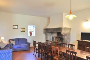 a living room with a dining table and a fireplace at Villa i Noccioli - 18 posti letto, piscina, parco in Capranica