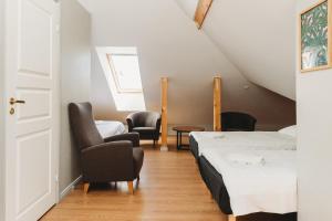 a room with two beds and chairs and a window at 16eur - Fat Margaret's in Tallinn
