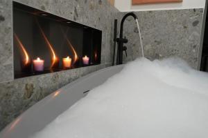 a bath tub with a fireplace with candles in it at Suite mit Badewanne, Kamin und Parkplatz in Graz