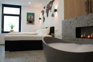 a bedroom with a bed and a tub and a fireplace at Suite mit Badewanne, Kamin und Parkplatz in Graz