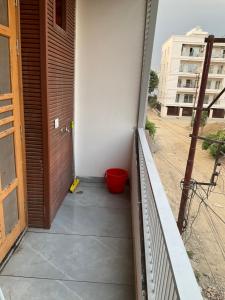 a balcony with a wooden door and a red bucket at Guru Ji Homes in Dehradun