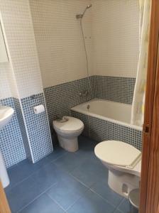 a bathroom with a toilet and a tub and a sink at Apartamento Villa de Venecia in Margudgued +3 photos