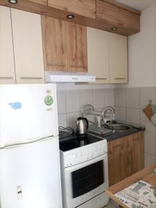 a kitchen with a stove and a white refrigerator at Stan na dan Drinska noć -Zvornik in Zvornik